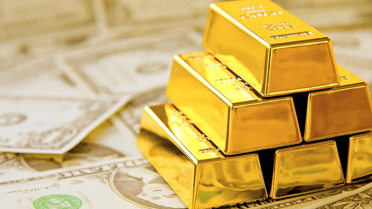 El oro sube por demanda de refugio, pero el dólar firme le pone techo